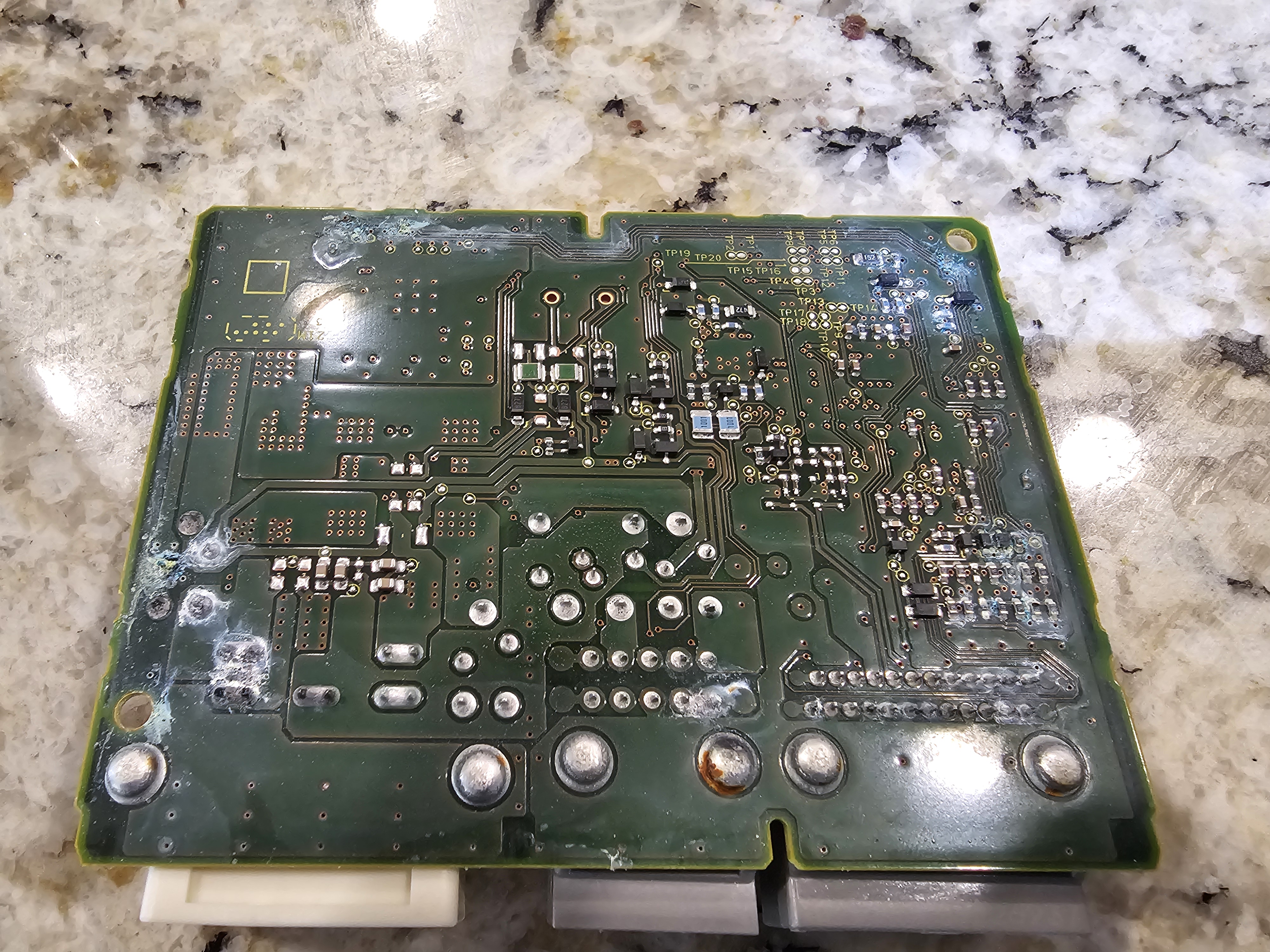 Close-up of circuit board corrosion showing dried water stains